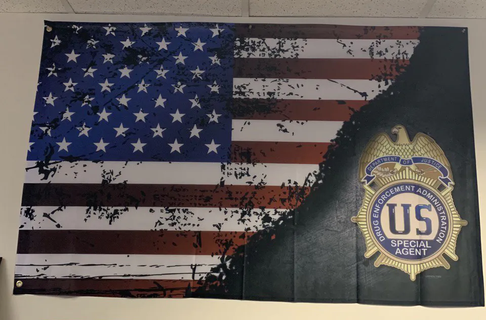 Distressed American flag with DEA Special Agent badge on an office wall